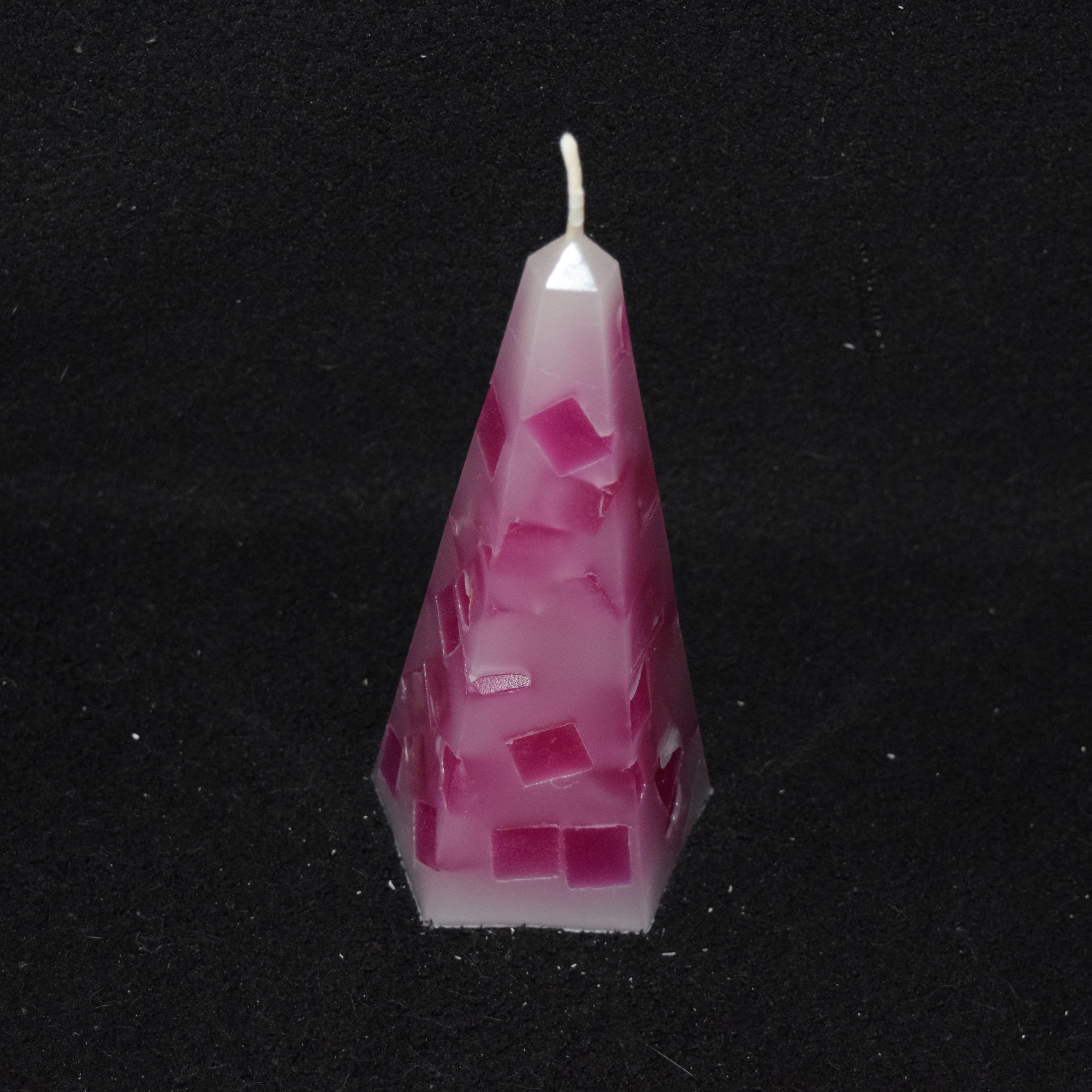 Obelisk-Kerze mit Würfeln gefüllt